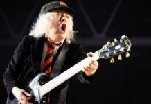 Angus Young verziert ein Baby mit seiner Unterschrift